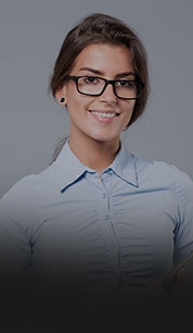 Mulher branca sorrindo usando camisa social e óculos de grau